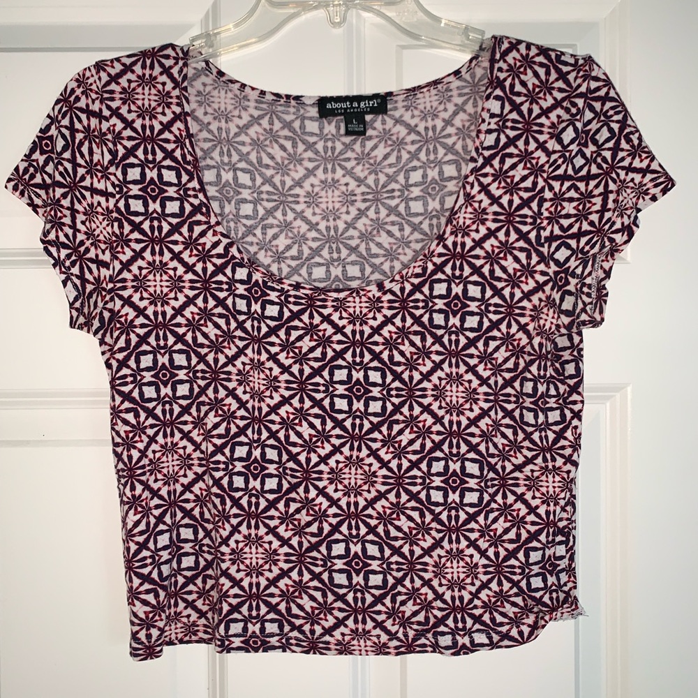 About a girl brand. Pink color with detailed print. It’s a large crop top.